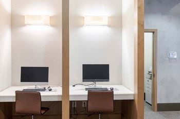 Two desks with computers and chairs in a room